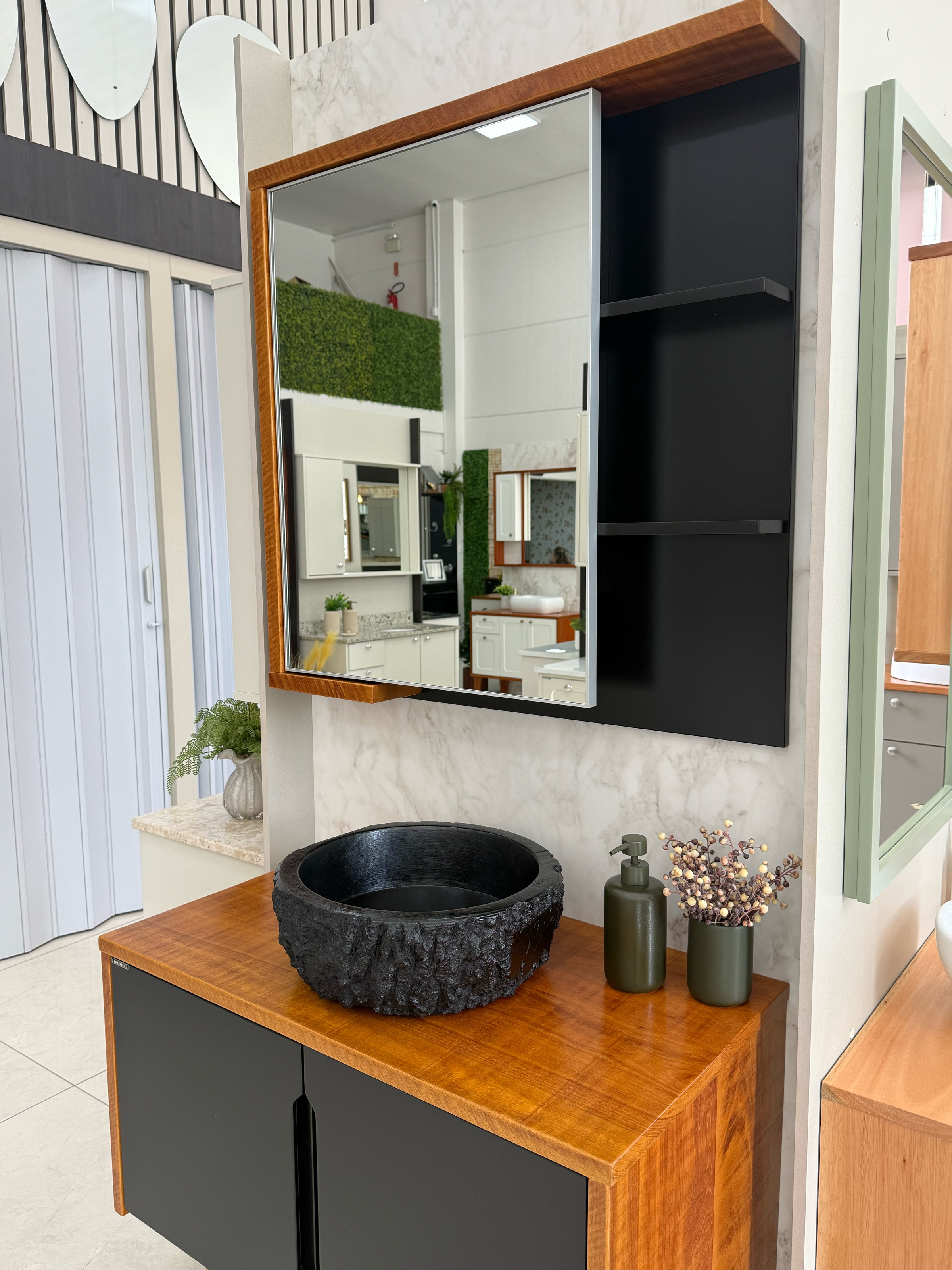 Foto real do detalhe da espelheira Lemie com espelho, moldura de madeira e nichos laterais escuros